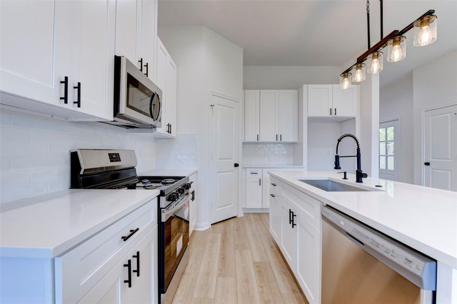 Functional kitchen layout featuring stainless steel appliances and ample cabinet storage.