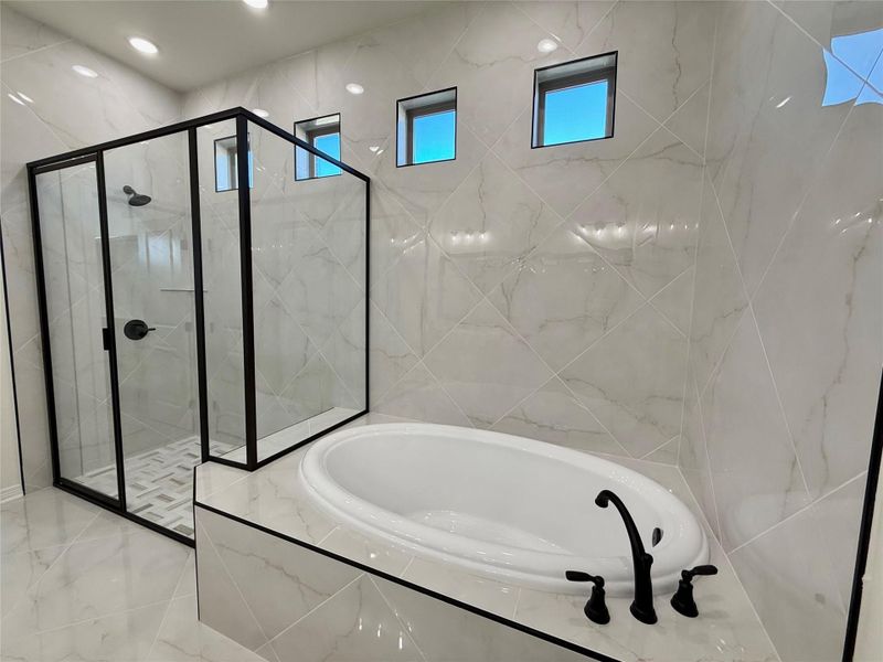 Full bath featuring a bath and a marble finish shower