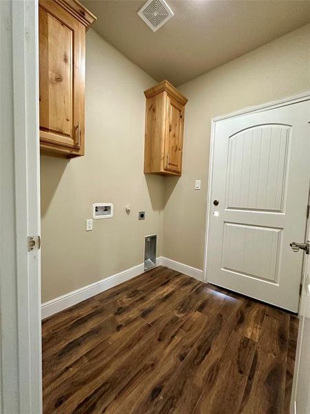 Laundry room featuring hookup for a gas dryer, electric dryer hookup, dark wood-type flooring, washer hookup, and cabinets