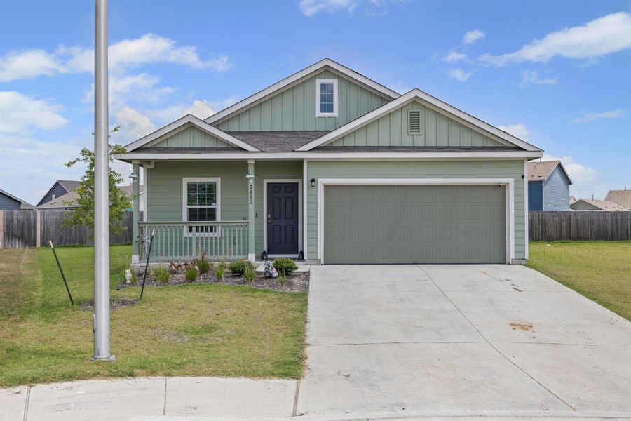 View of front facade with a porch, concrete driveway, a garage, and board and batten siding View of front facade with a porch, concrete driveway, a garage, and board and batten siding