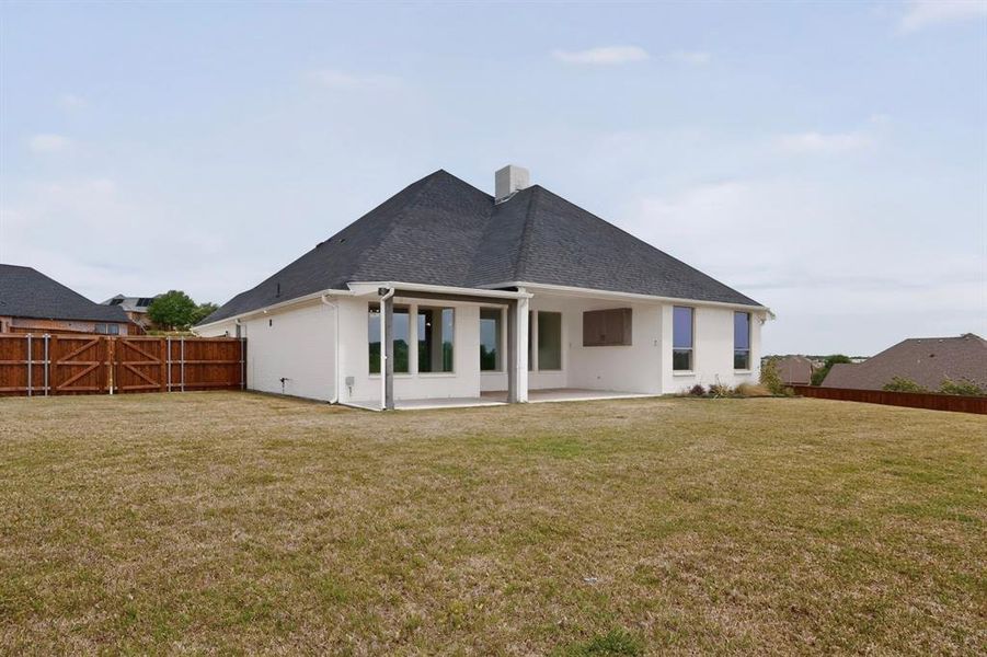 Expansive backyard featuring a brown wooden privacy fence and a large concrete patio Expansive backyard featuring a brown wooden privacy fence and a large concrete patio