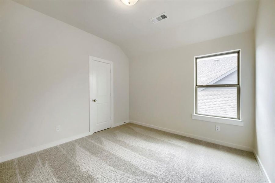 Neutral-toned interior room featuring light-colored walls and patterned carpet flooring Neutral-toned interior room featuring light-colored walls and patterned carpet flooring