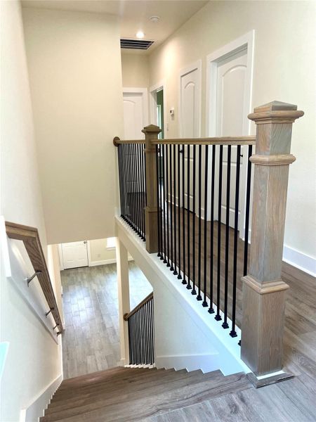 Staircase with elegant wood and metal railings, leading to a bright upper hallway. Staircase with elegant wood and metal railings, leading to a bright upper hallway.