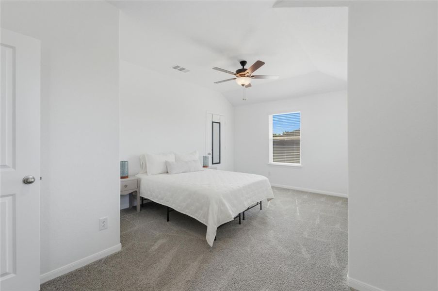 A well-lit bedroom features vaulted ceilings and ample natural illumination. A well-lit bedroom features vaulted ceilings and ample natural illumination.