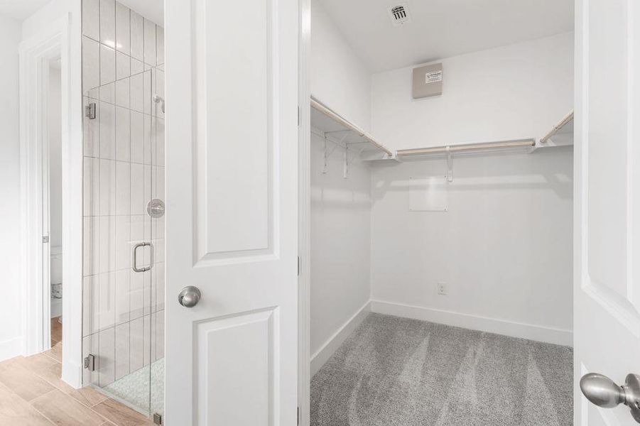 Ample storage solutions feature a walk-in closet and adjacent full bathroom with tiled shower. Ample storage solutions feature a walk-in closet and adjacent full bathroom with tiled shower.