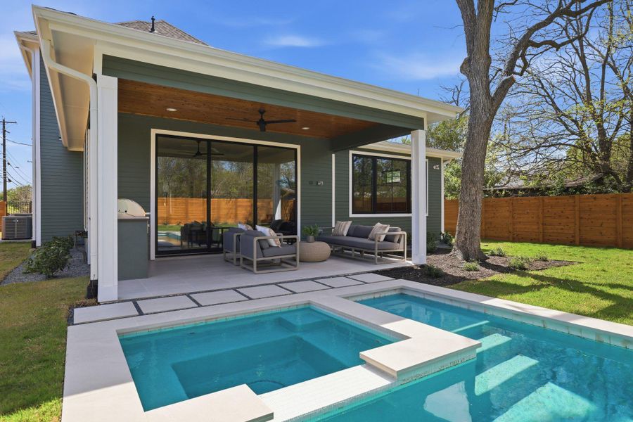 Back of property featuring ceiling fan, a patio area, an outdoor lounge area, and a pool with connected hot tub