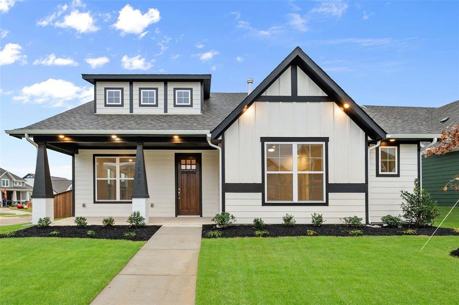 View of front of property with a front yard and covered porch