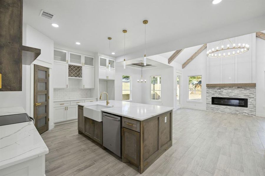 Kitchen featuring a healthy amount of sunlight, lofted ceiling with beams, dishwasher, and white cabinets