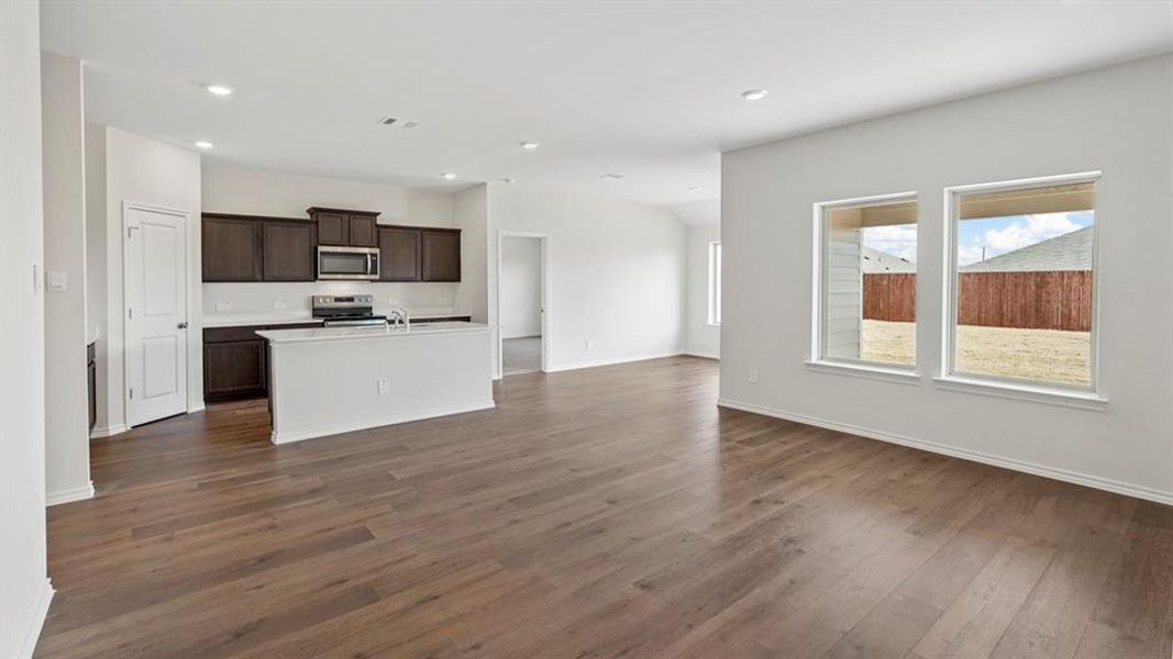 Open-concept interior featuring wood-finish flooring, white walls, and recessed lighting