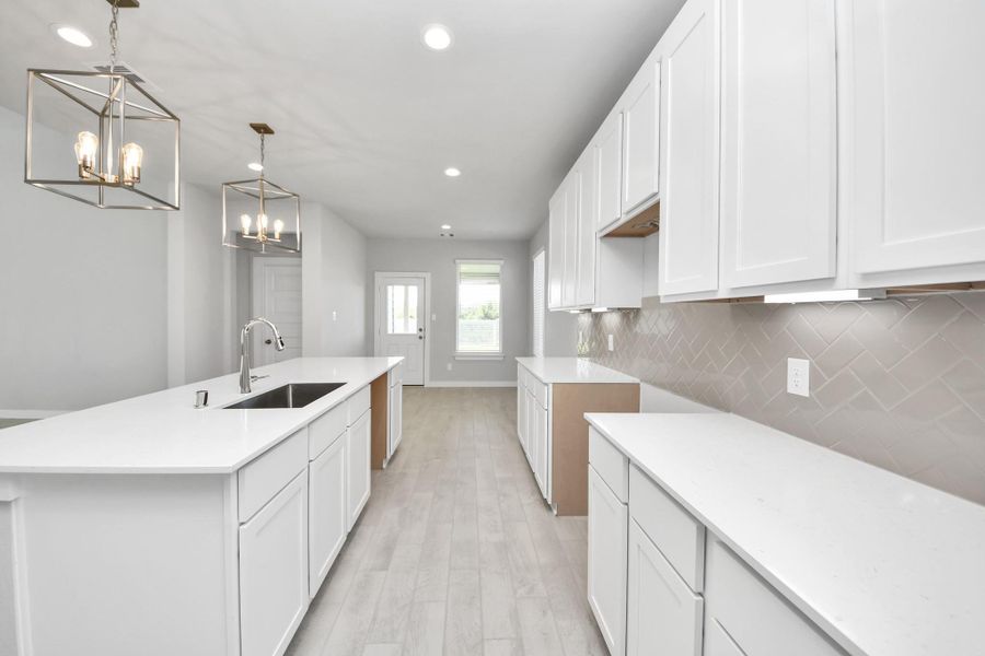 The extended counter area adds both practicality and style, making meal preparation a breeze. Every detail is thoughtfully designed to enhance the kitchen's functionality and aesthetic appeal. Sample photo of completed home with similar floor plan. Actual colors and selections may vary.