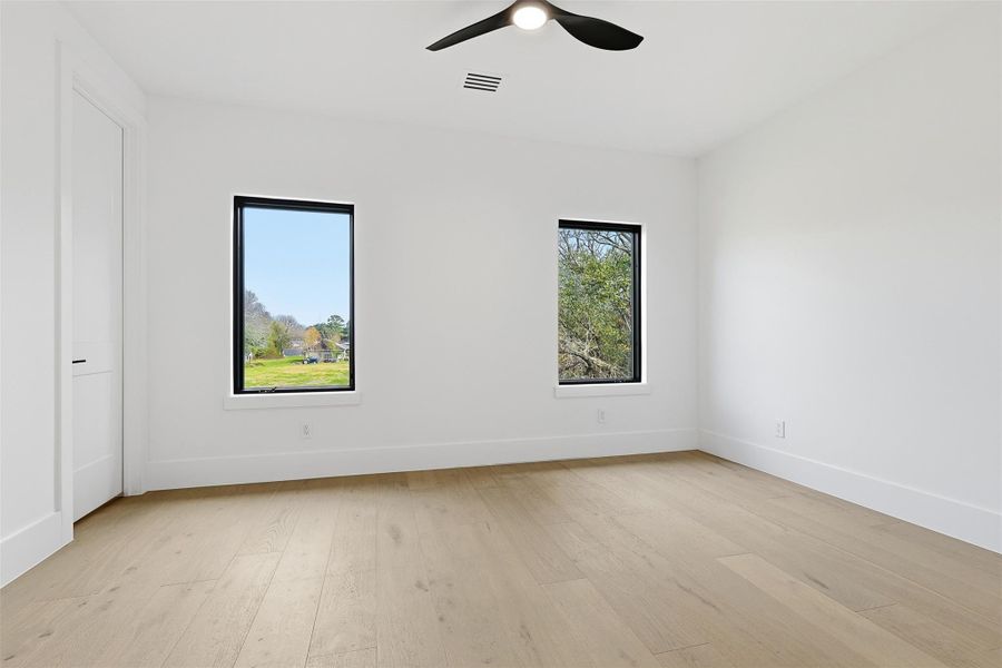 This secondary bedroom offers wood-look flooring and windows with views of the surrounding landscape.