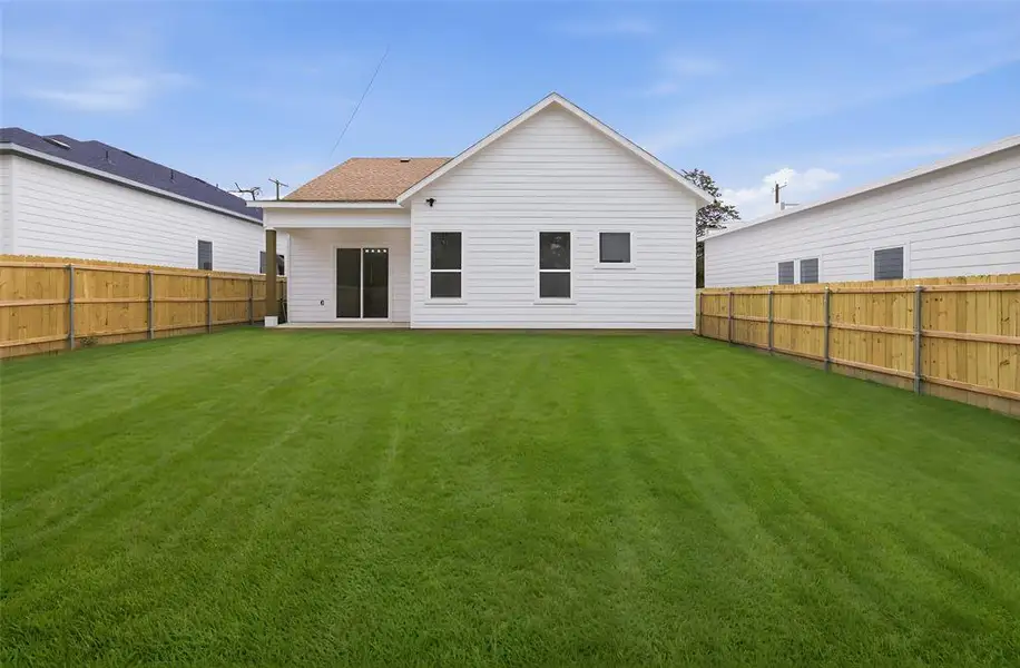 Back of house featuring a fenced backyard and a shingled roof
