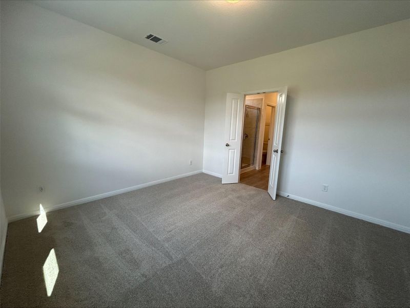 Empty room with carpet flooring and baseboards Empty room with carpet flooring and baseboards