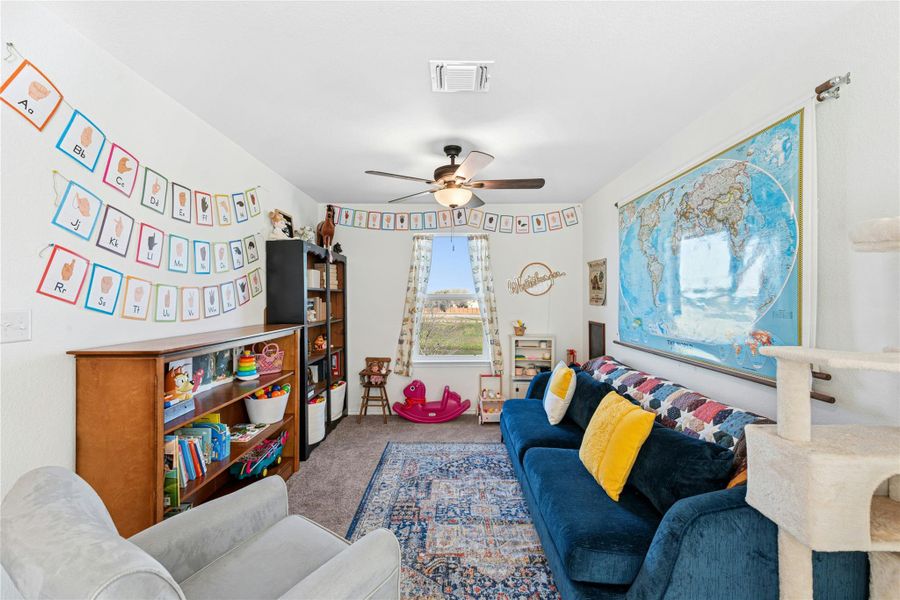 A bright and welcoming second-floor playroom featuring plush carpeting and a spacious layout, enhanced by an abundance of natural light—perfect for relaxation, creativity, or additional living space.