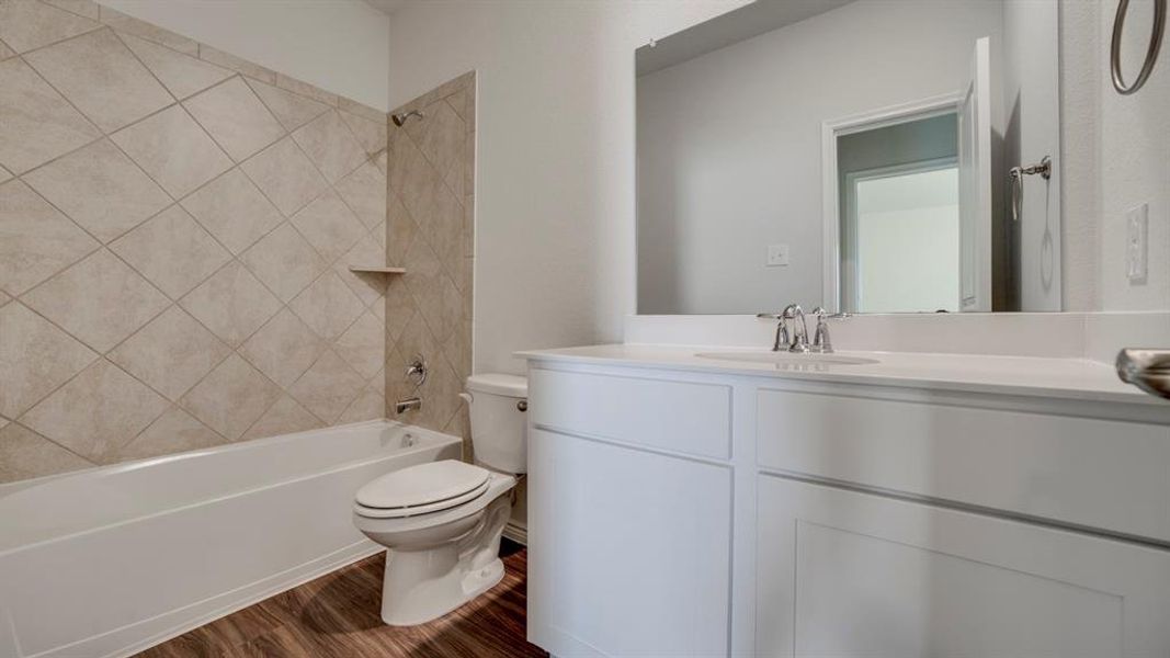 Full bathroom featuring vanity, shower / bath combination, and dark wood finished floors