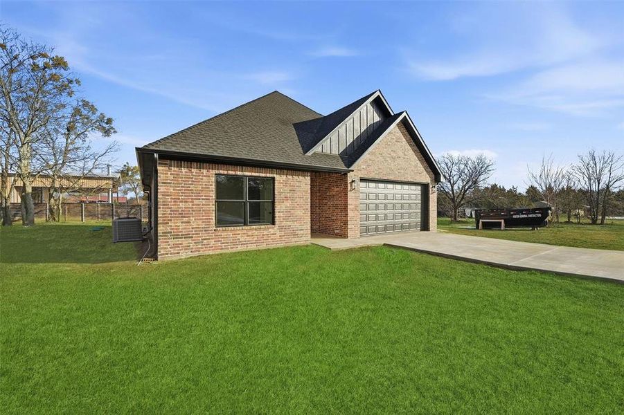 View of front of house featuring concrete driveway, brick siding, a shingled roof, and a front yard View of front of house featuring concrete driveway, brick siding, a shingled roof, and a front yard