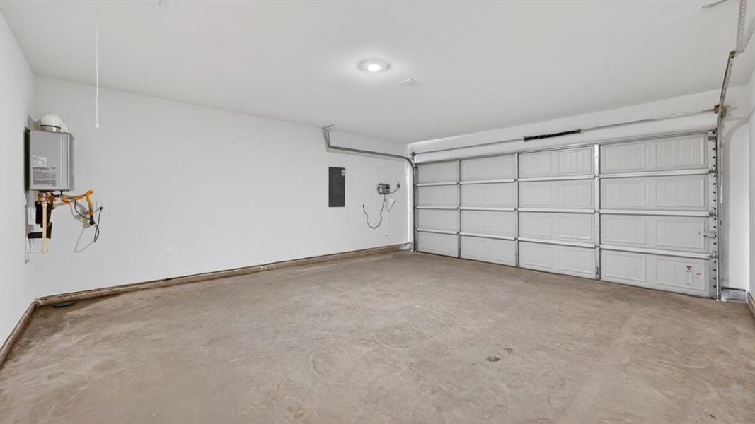 Spacious garage featuring a concrete floor, white walls, and a paneled garage door