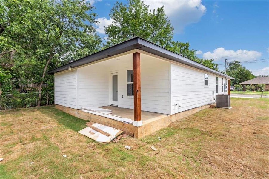 Back of house featuring back porch with a fenced in backyard and exterior AC unit