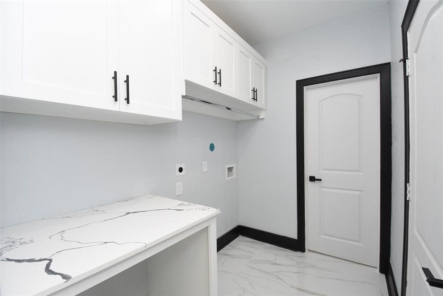 The utility room inside the home is spacious, with storage cabinets and plenty of space.