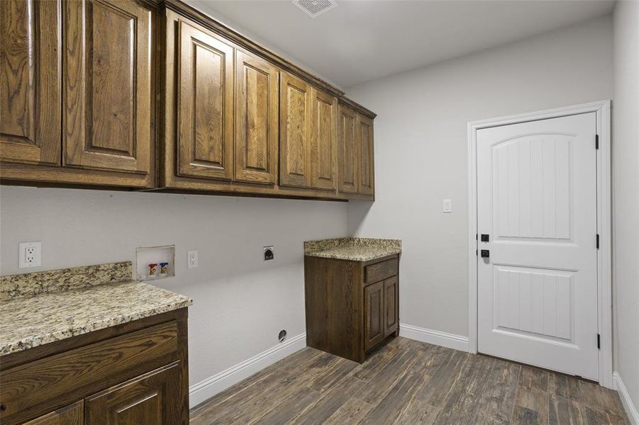 Laundry area featuring electric dryer hookup, dark hardwood / wood-style flooring, cabinets, and hookup for a washing machine