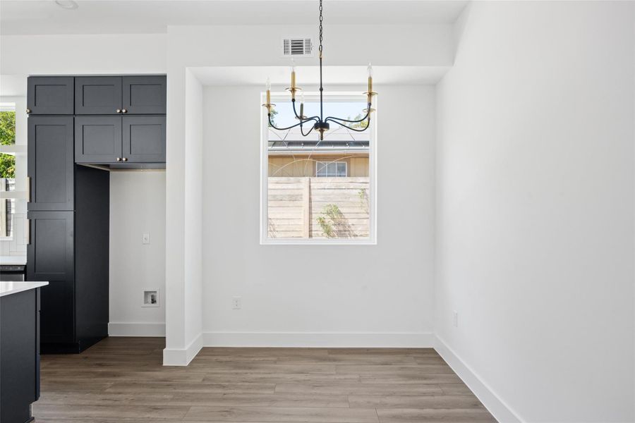 Unfurnished dining area with light wood-style flooring and a chandelier Unfurnished dining area with light wood-style flooring and a chandelier