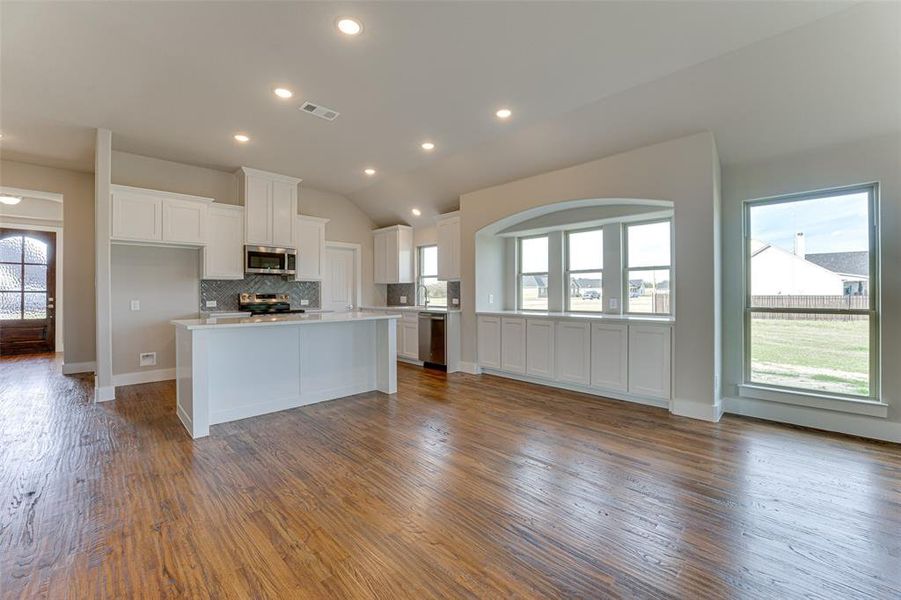 Kitchen with white cabinets, plenty of natural light, dark hardwood / wood-style flooring, and appliances with stainless steel finishes