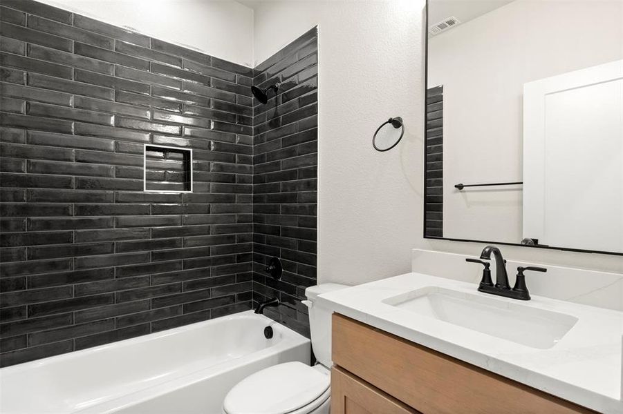 Bathroom featuring vanity, shower / washtub combination, and a textured wall