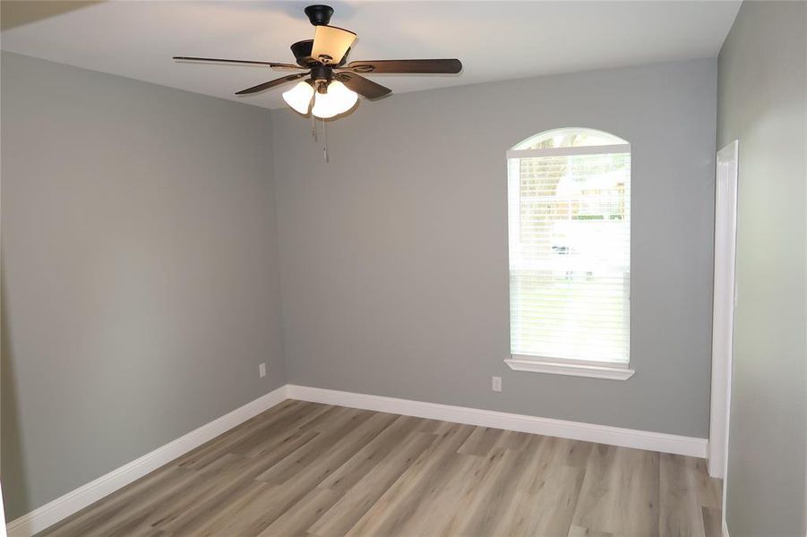 Empty room with light wood-type flooring and ceiling fan