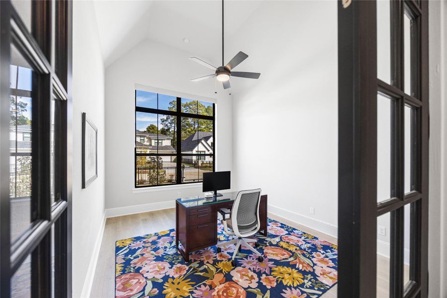 Study located at the front of the home with black double doors.