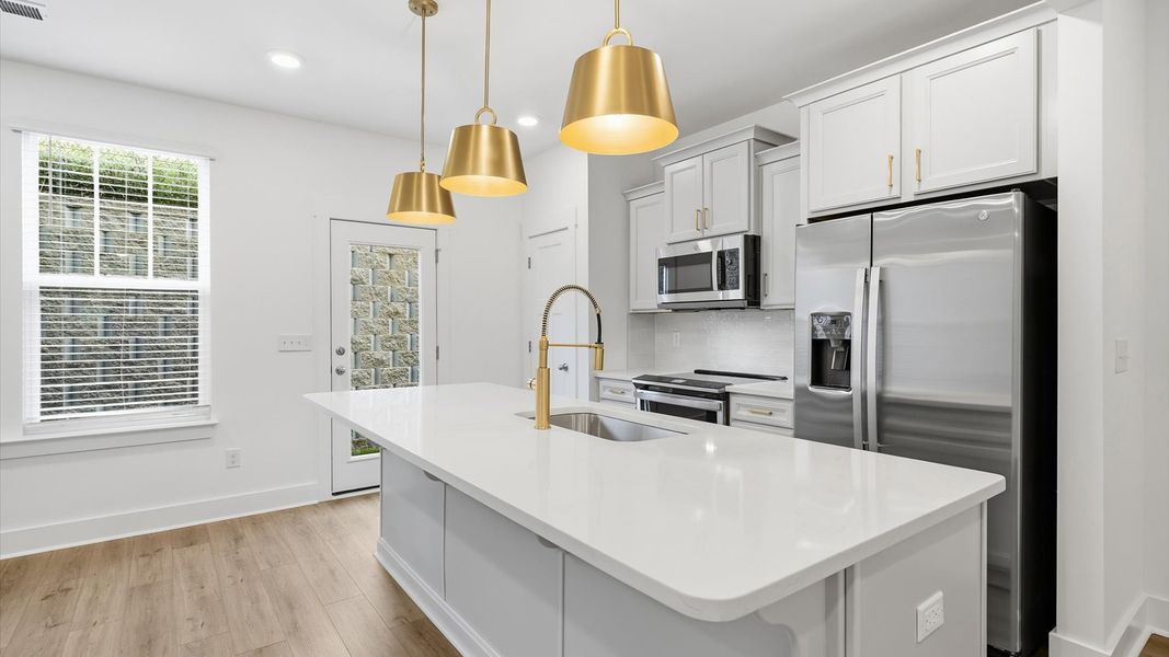 Memorable meals begin in this vibrant kitchen with pendant lighting and a thoughtfully designed island