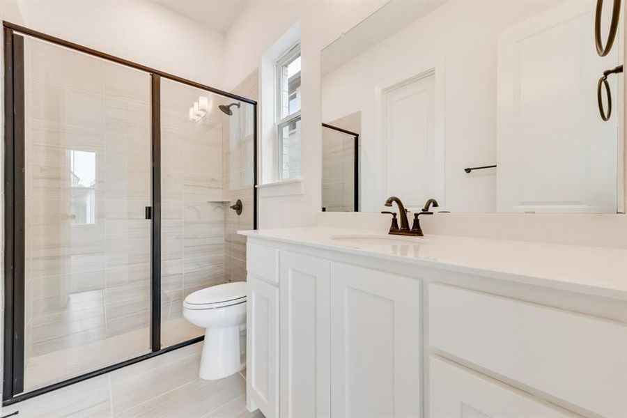 Bathroom with a stall shower, vanity, and light tile patterned floors Bathroom with a stall shower, vanity, and light tile patterned floors