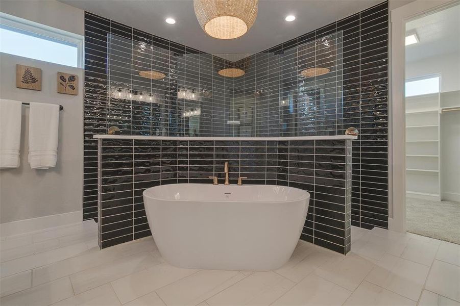 Bathroom with tile patterned flooring, tile walls, and plus walk in shower