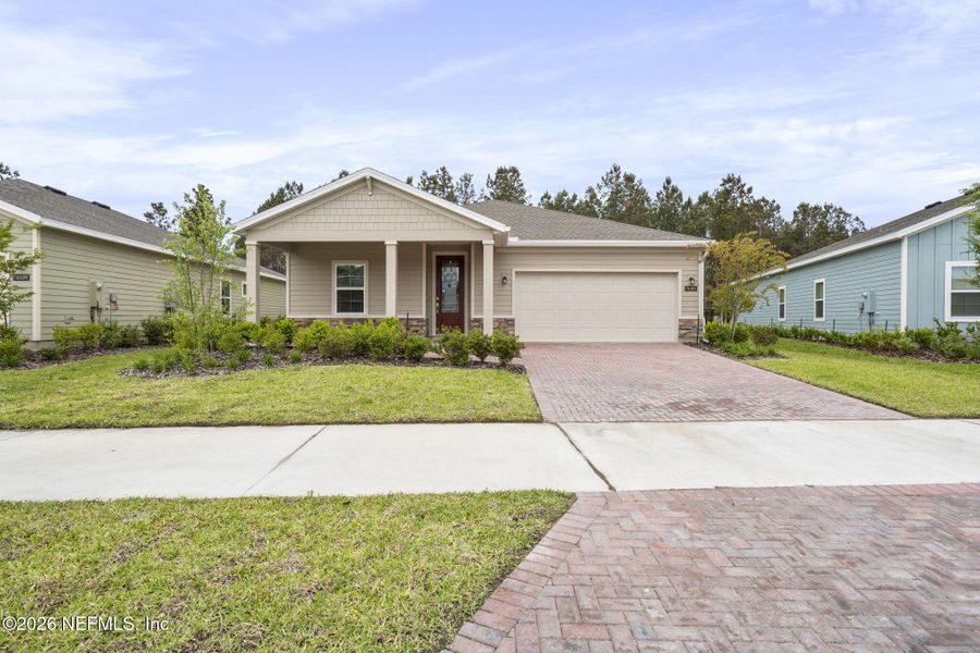Front exterior of a new home in Tributary, Yulee, FL, highlighting curb appeal (Image 21). Front exterior of a new home in Tributary, Yulee, FL, highlighting curb appeal (Image 21).