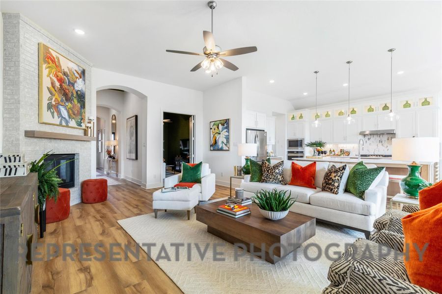Living room featuring recessed lighting, arched walkways, ceiling fan, and light wood finished floors Living room featuring recessed lighting, arched walkways, ceiling fan, and light wood finished floors