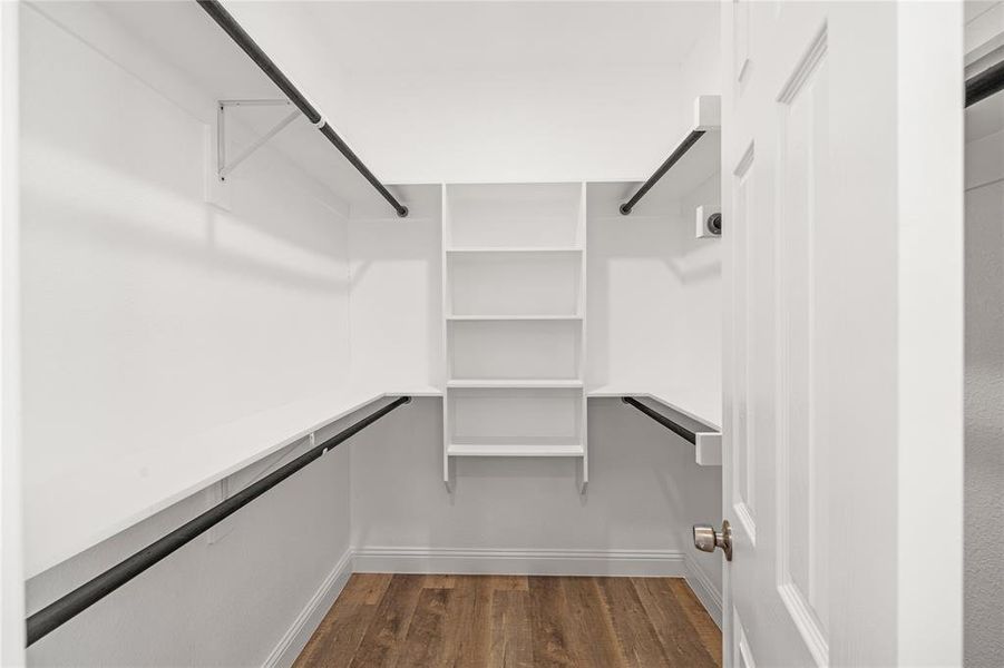 Walk in closet with dark wood-type flooring