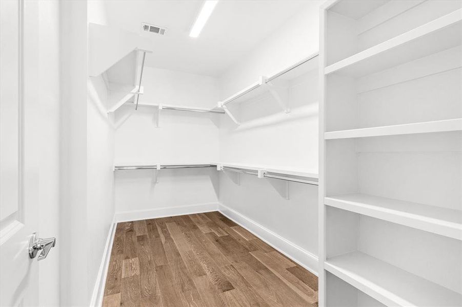 Walk in closet featuring dark wood-style flooring Walk in closet featuring dark wood-style flooring