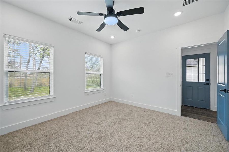 Carpeted spare room featuring baseboards, visible vents, and recessed lighting