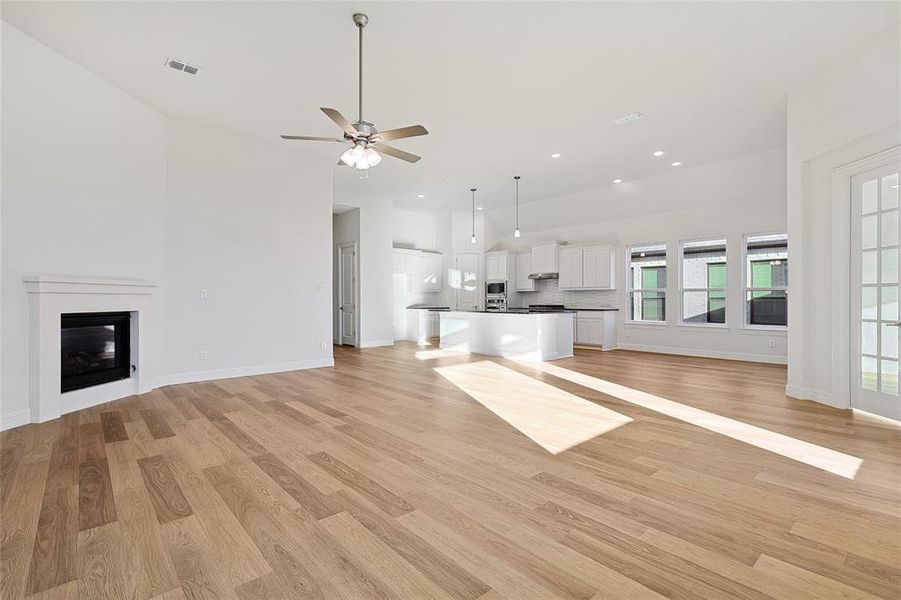 Unfurnished living room with ceiling fan and light hardwood / wood-style floors