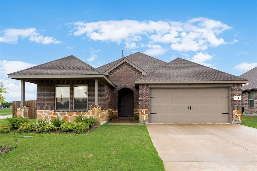 Single story home featuring brick siding, a shingled roof, and an attached garage