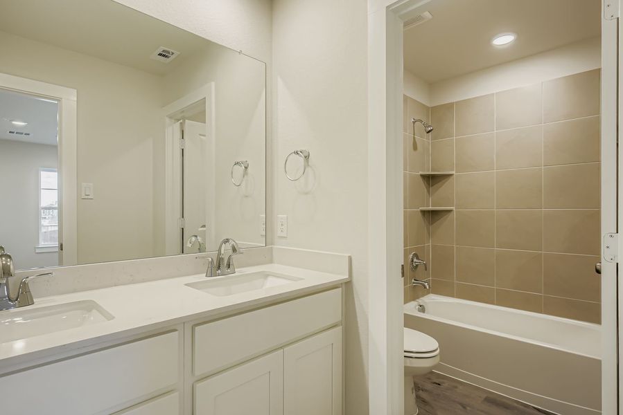 A bathroom with a tub sink and toilet.