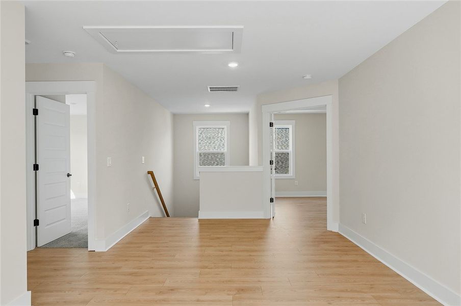 Smooth wood floors and recessed lighting anchor th