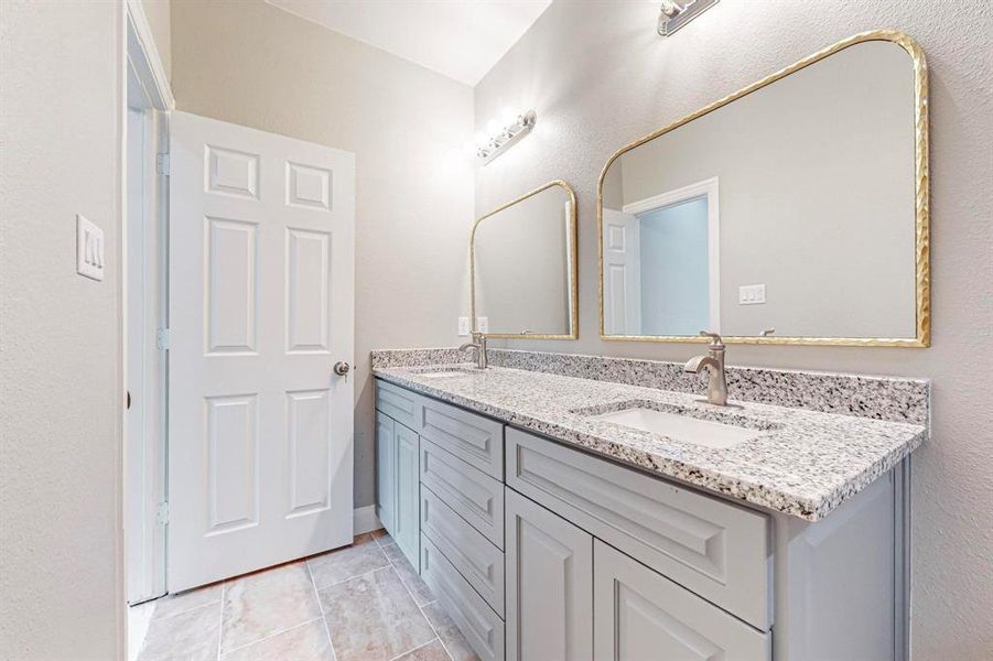 Bathroom with tile flooring and double sink vanity