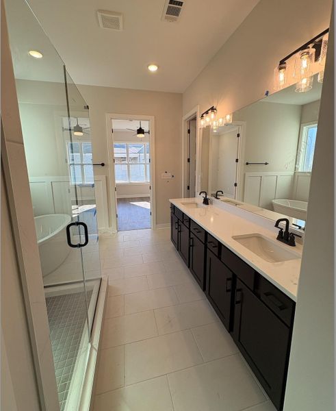 Full bathroom featuring a soaking tub, double vanity, a shower stall, recessed lighting, and ceiling fan