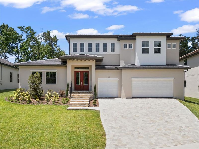 This brand-new, custom-built home showcases stunning curb appeal with a modern architectural design, a beautiful paver driveway, and an oversized three-car garage. The meticulously manicured landscaping and grand front entry invite you into a home where luxury and comfort seamlessly blend.