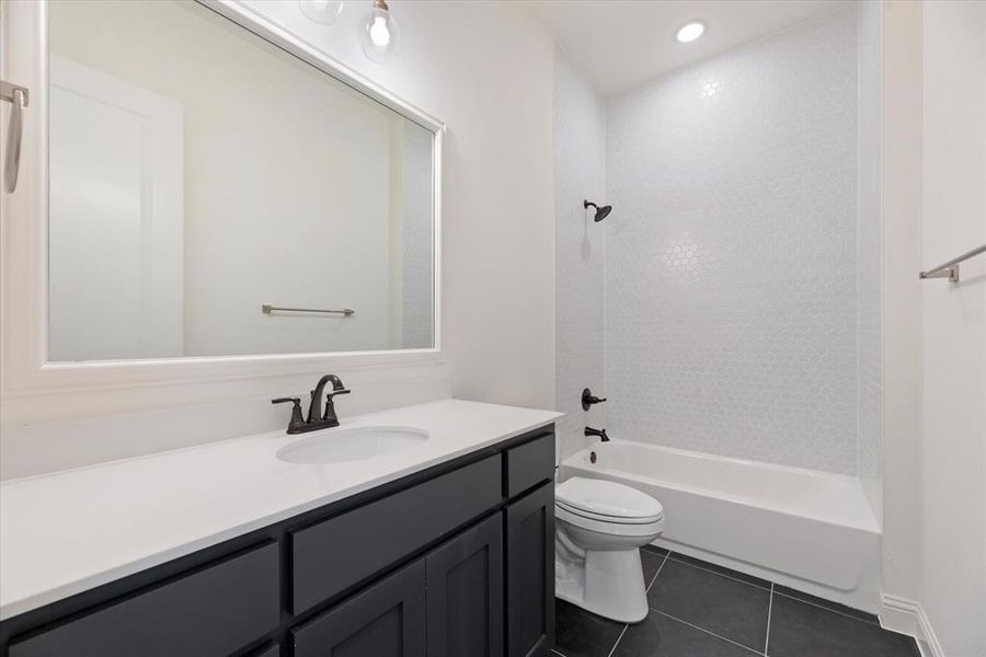 Full bathroom featuring vanity, toilet, tile patterned floors, and bathing tub / shower combination