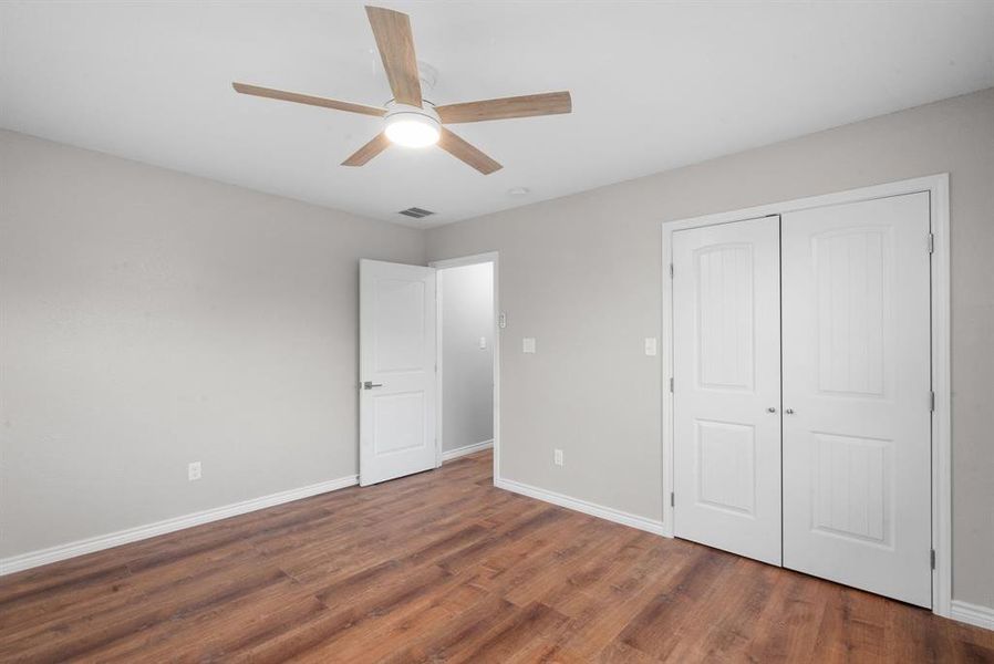 Unfurnished bedroom with a closet, ceiling fan, and dark hardwood / wood-style floors Unfurnished bedroom with a closet, ceiling fan, and dark hardwood / wood-style floors