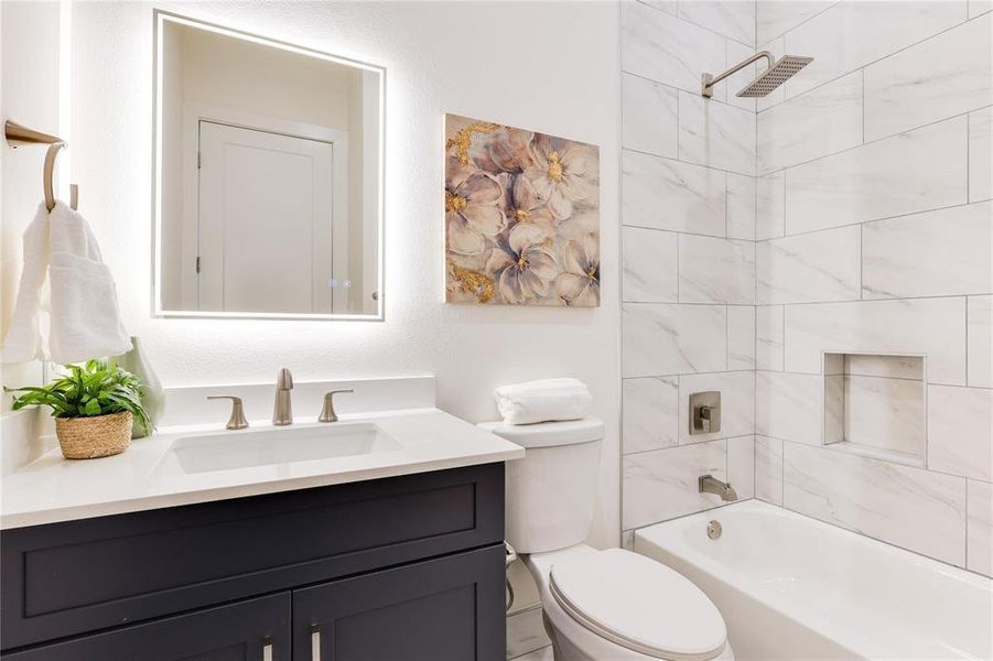 Full bathroom featuring vanity, toilet, and tiled shower / bath combo