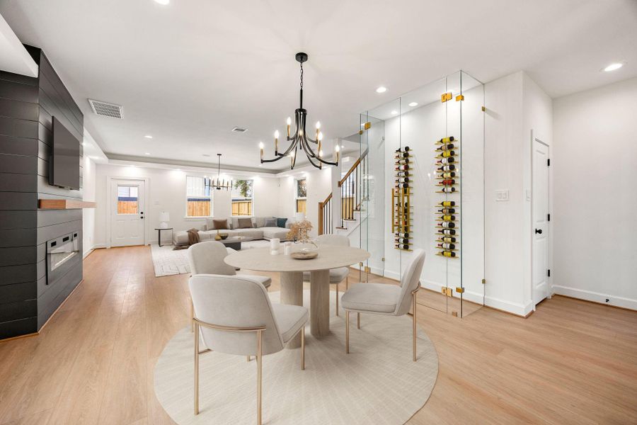Elegant dining area seamlessly connected to the kitchen and living room, featuring warm wood floors, modern chandelier, and a spacious layout ideal for entertaining. The open-concept design offers excellent flow, abundant natural light, and stylish contemporary finishes throughout.