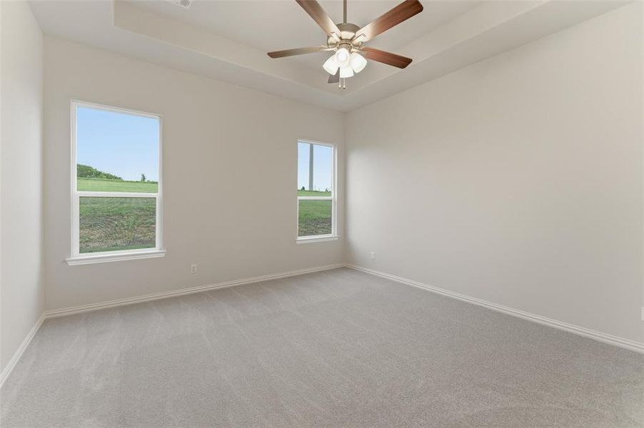 Spacious room featuring light-colored walls and soft gray carpeting
