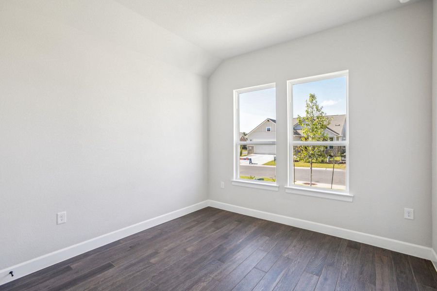 Unfurnished room with dark wood-style flooring and vaulted ceiling Unfurnished room with dark wood-style flooring and vaulted ceiling
